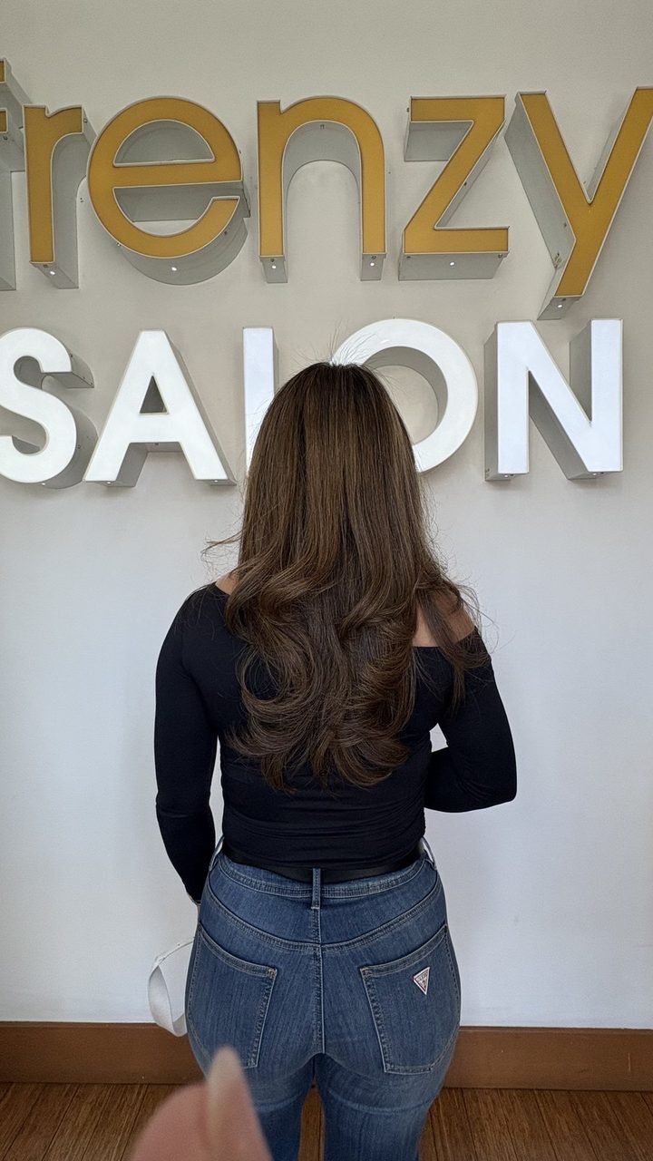 Dimensional color result in front of the Frenzy Salon sign