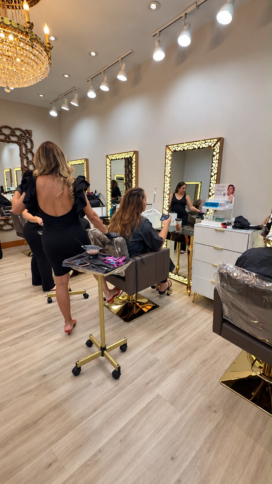 Interior of Frenzy Salon with gold-framed mirrors and a crystal chandelier